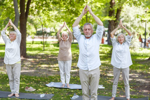 istock Group of old people doing qigong exercise in the park 1176536065