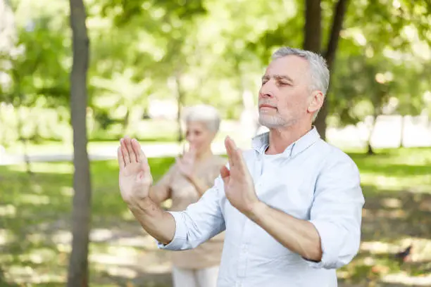 Senior man practicing chi kung in the park stock photo