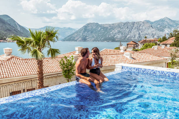 padres jóvenes que tienen algún tiempo para sí mismos junto a la piscina - swimming pool resort swimming pool poolside sea fotografías e imágenes de stock