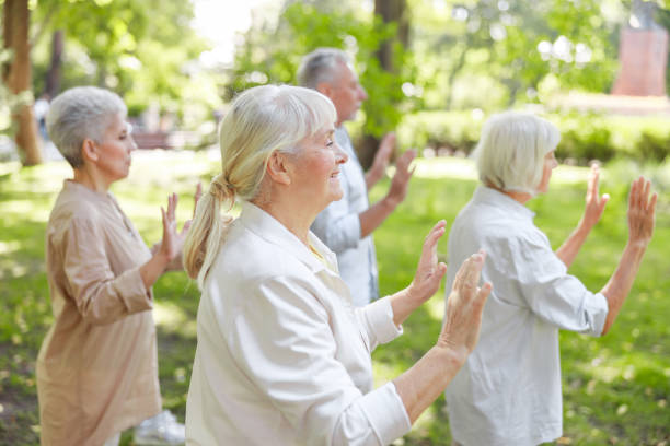 istock Smiling old lady practicing qigong with friends 1176536527