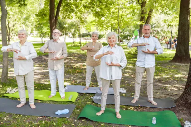 Group of old people doing healing chi kung exercise stock photo