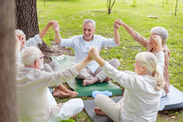 istock Smiling old people sitting in circle and holding hands 1176538467