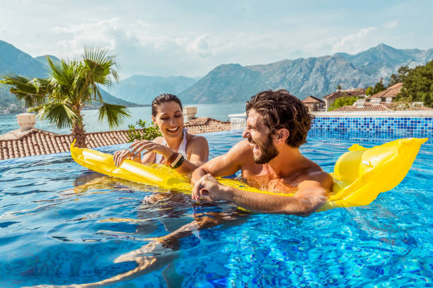 istock playful couple smiling in a pool 1176539549