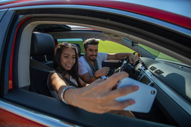 istock Happy beautiful young couple taking a selfie in a car 1176540065
