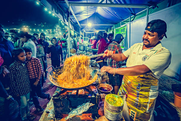 Chef de comida de rua faz e vende macarrão na feira Himachal Utsav. - foto de acervo