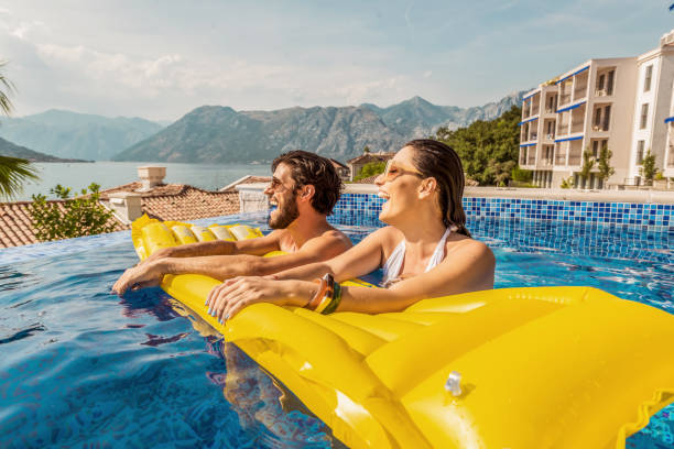 istock playful couple smiling in a pool 1176542772