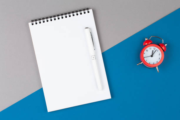 istock open notebook with pen on blue and gray table top view, with blank page 1176545987