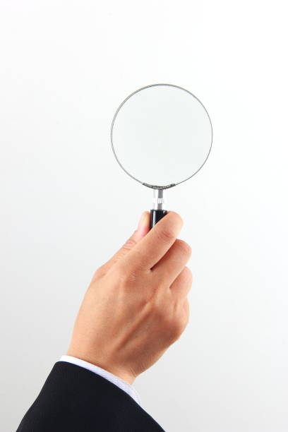 istock Woman hand holding magnifying glass on white background 1176546084