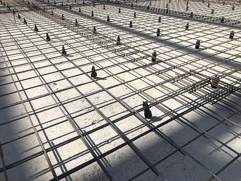 Metal reinforcement grid with plastic holders. Reinforced concrete preparation. Concrete basement construction.