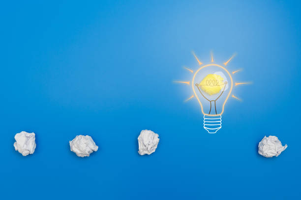 istock New idea and creativity concept with crumpled office paper balls and glowing light bulb 1176552077