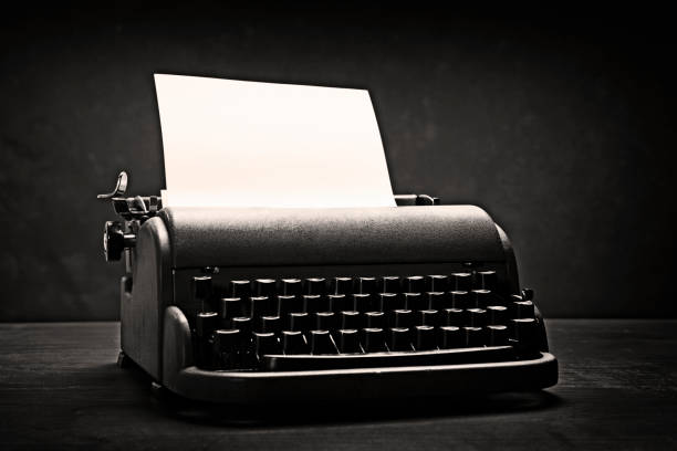 istock Retro mid-20th-century typewriter in dramatic black and white, with blank paper 1176552089