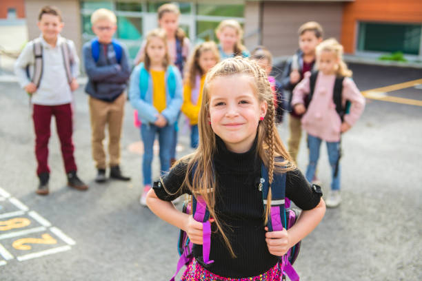 istock A schoolgirl standing with other student on the back 1176554171