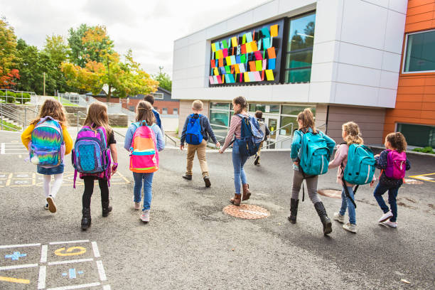 groupe d'enfants vont à l'école, retour vue - schoolyard photos et images de collection