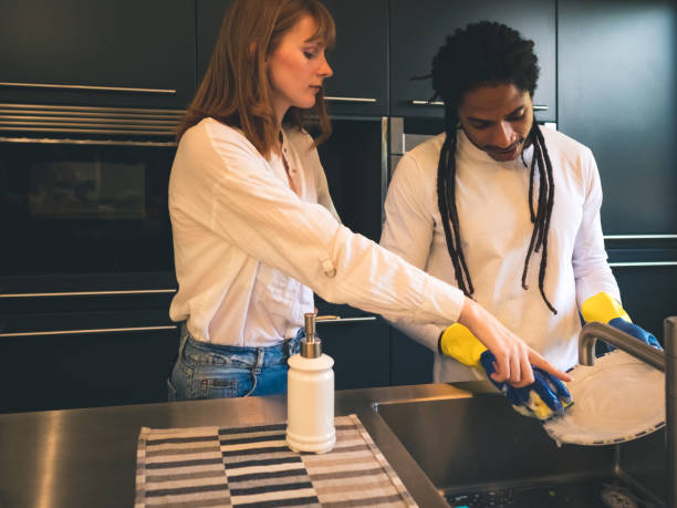 istock young boy with dreadlocks scrubbing while his angry girlfriend tells him where the dish is still dirty 1176554830