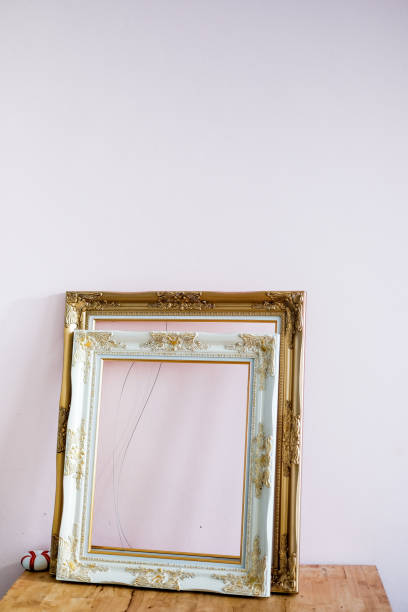 istock Decoration : Antique White and golden frame isolated on small table in white background, blank picture frame placed on wooden desk . Vintage style 1176554937