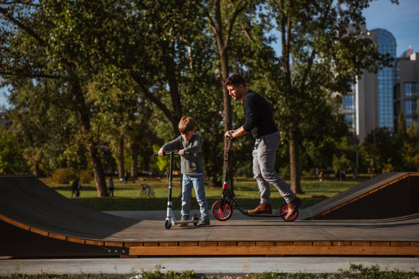 istock Little boy riding a push scooter with his dad 1176555118