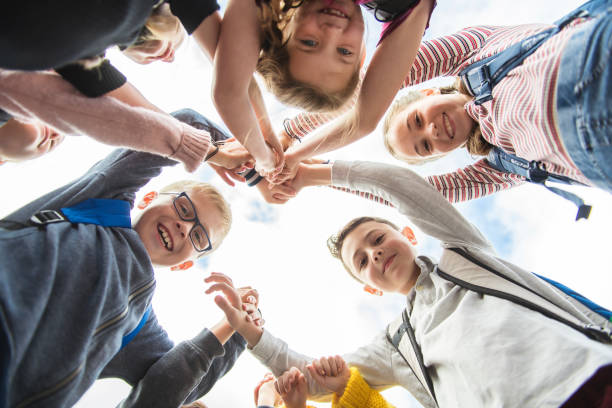 istock A Group of school child standing together with hand over 1176555250