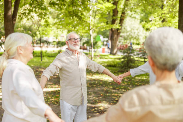 istock Smiling elderly people standing in circle and holding hands 1176557068