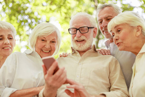 istock Smiling senior people using cellphone on the street 1176557124