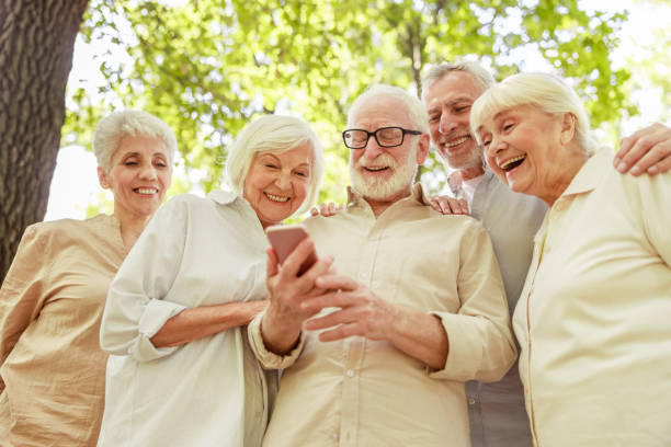 istock Cheerful old people using cellphone on the street 1176557162