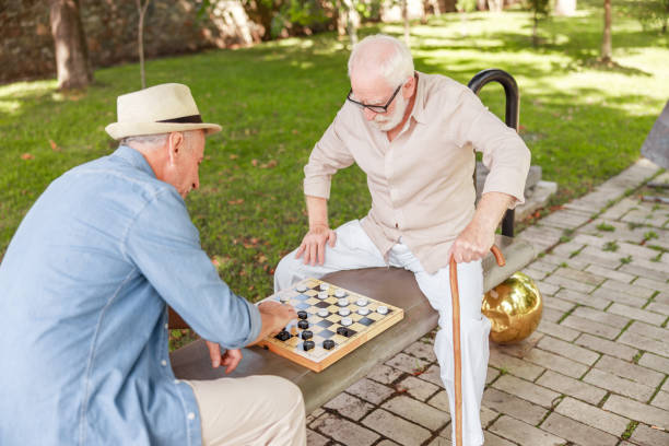 istock Two old gentlemen playing checkers on the street 1176557271