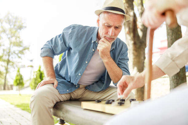 istock Mature man playing checkers with friend outdoors 1176557300
