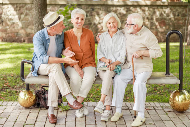 istock Cheerful old people sitting on bench and talking 1176557381
