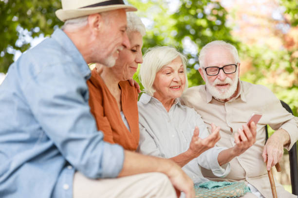 istock Smiling old friends using smartphone on the street 1176557450