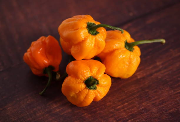 istock Orange chili peppers on wooden table 1176557455