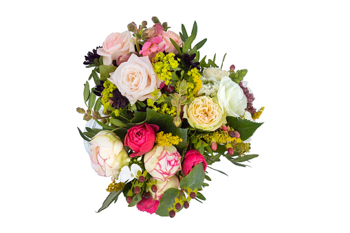 a funeral wreath with a white ribbon and many colourful flowers on a grave after a funeral