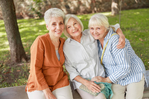 istock Joyful old women sitting on bench in the park 1176557514