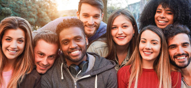 istock Happy millennial friends from diverse cultures and races having fun posing in front of smartphone camera - Youth and friendship concept - Young multiracial people smiling - Main focus on african man 1176559812