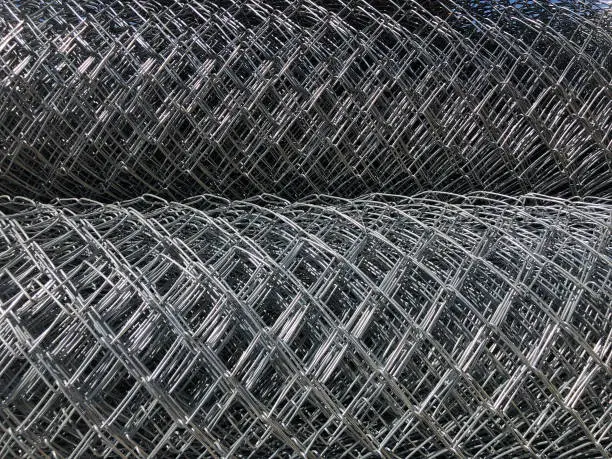 Rolled chain-link fence. Metal mesh netting rolled into rolls.