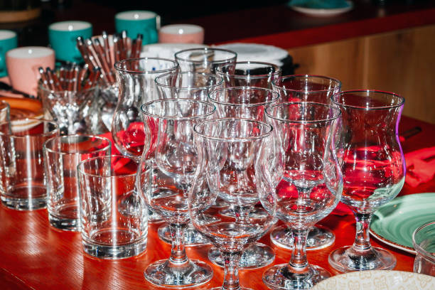 istock Rows of glass glasses on a red counter, a low key image. 1176560098