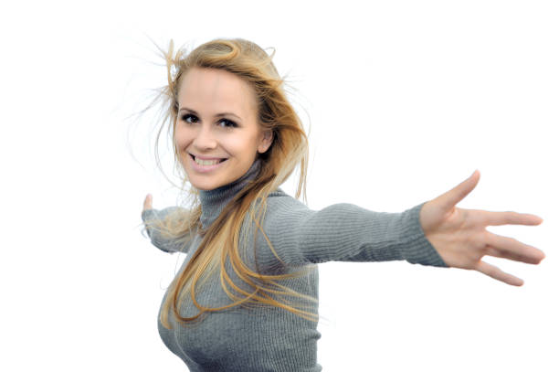 Close up of the face of an attractive blonde mature woman in her forties, with a mischievous smile and a winking eye