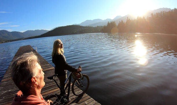 istock Couple walk bikes along lakeside pier at sunrise 1176560868