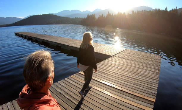 istock Couple walk along lakeside pier at sunrise 1176561100