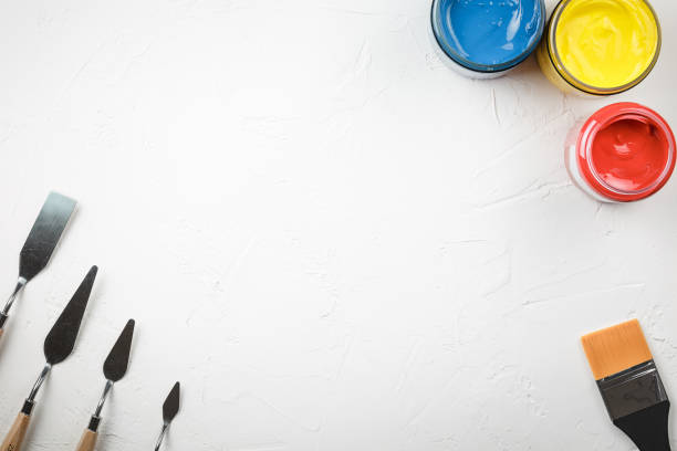 istock colored paints and palette knives on white background 1176561213