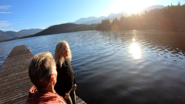 istock Couple walk along lakeside pier at sunrise 1176562004