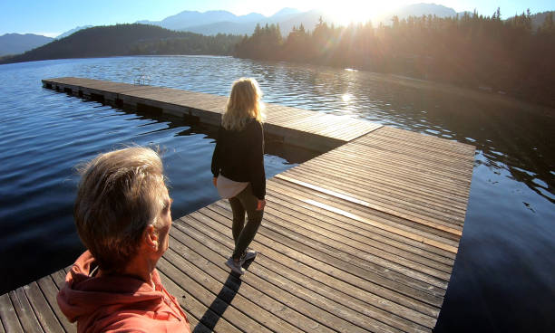 istock Couple walk along lakeside pier at sunrise 1176562044