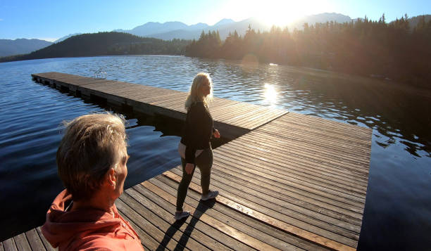 istock Couple walk along lakeside pier at sunrise 1176562079