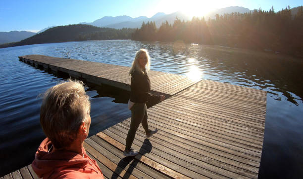 istock Couple walk along lakeside pier at sunrise 1176562277
