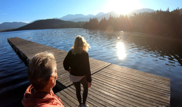istock Couple walk along lakeside pier at sunrise 1176562297