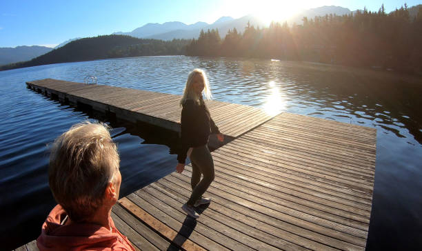 istock Couple walk along lakeside pier at sunrise 1176562314
