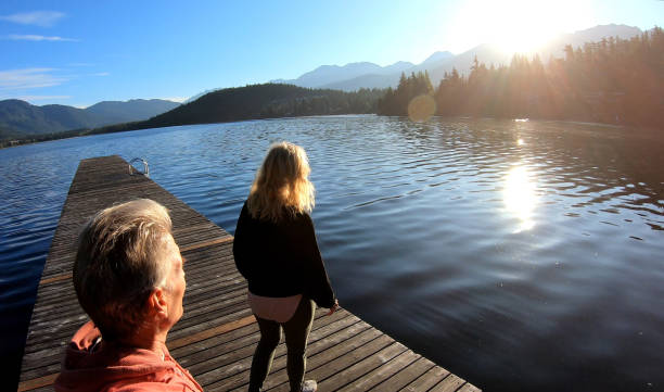 istock Couple walk along lakeside pier at sunrise 1176562443