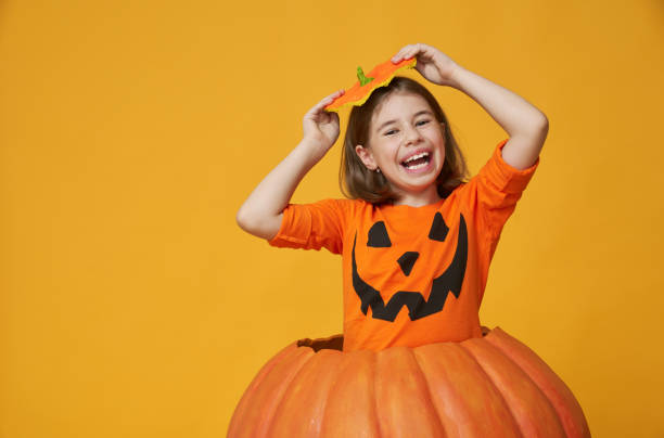 little girl in pumpkin costume stock photo