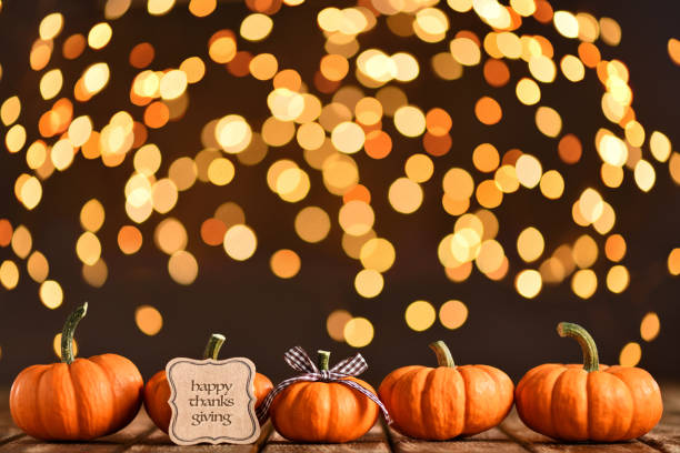 istock Thanksgiving still life with pumpkins and greeting card on illuminated background and a rustic wooden table 1176564520