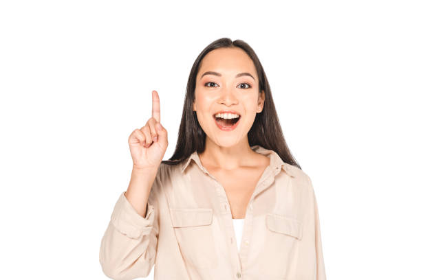 istock cheerful asian woman showing idea sign while looking at camera isolated on white 1176567106