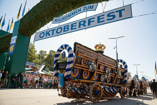 Munich, Germany - September 21, 2019: Welcome sign with the opening parade of the Oktoberfest in Munich. The Oktoberfest is the biggest beer festival of the world. 9000 participants take part with historical costumes, music bands and horses.