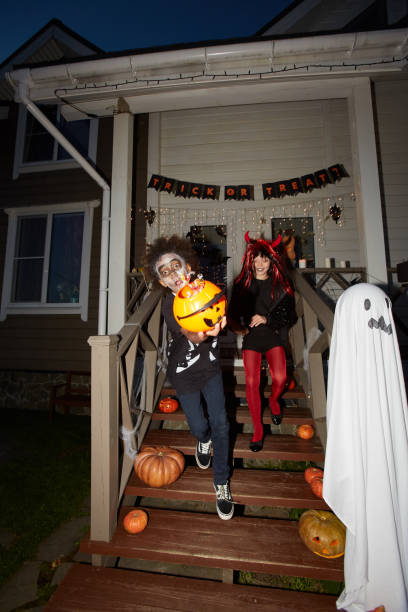 ハロウィーンで走り出す子供たち - three person family flash ストックフォトと画像